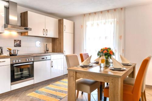 巴特霍夫加施泰因Apartments Davydov的一间带木桌和椅子的厨房以及一间用餐室