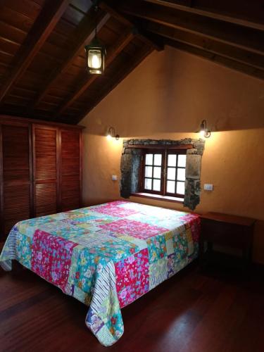 拉奥罗塔瓦El pajar de Inés的一间卧室配有一张带彩色床罩的床