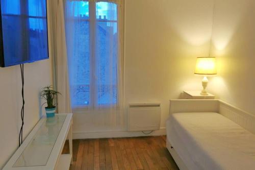圣日耳曼昂莱Wei&Pei Apartment - Hypter Center St Germain En Laye 1min RER的一间卧室配有一张床、一张书桌和一个窗户。