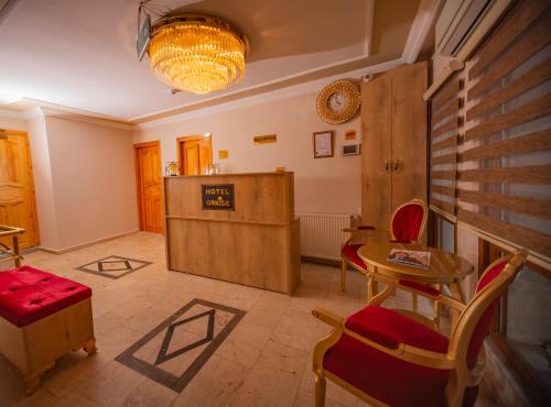 伊斯坦布尔Hotel Orkide的一间带桌椅的客厅和一间房间