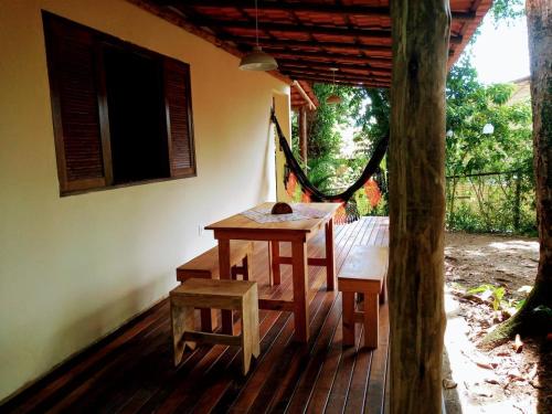 阿布拉奥Vivenda Cravo&Canela的木桌和木凳,位于带树门廊上