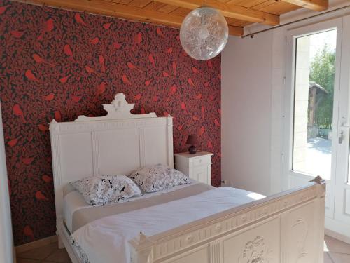 阿维尼翁新城Chambre avec tout le confort d'un appartement的卧室配有白色的床铺和红色壁纸
