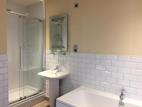 亨斯坦顿Marine Bar Pub with Rooms的白色的浴室设有水槽和淋浴。
