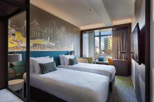 奥克兰Mercure Auckland Queen Street的酒店客房设有两张床和窗户。