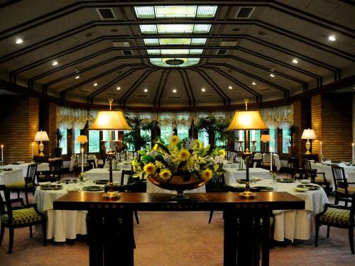 白马村Hotel La Neige的一间带桌椅和花瓶的用餐室