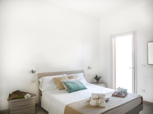 托里德欧索Appartamenti Via Corfù - Le vie di Omero的白色的卧室设有床和窗户