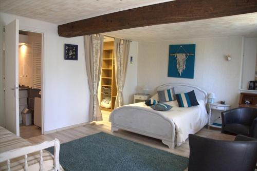 Saint-Ouen-des-ToitsChambre d hote La Roussiere的一间卧室,卧室内配有一张床和一把椅子