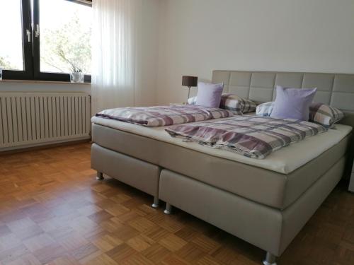 KreuzwertheimFeWo mit Burgblick的一间卧室配有一张带紫色枕头的大床
