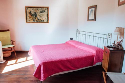 Vezzi PortioLe Petit Chateau的一间卧室配有一张带粉色毯子的床