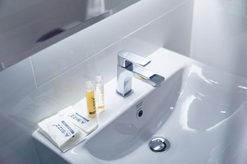 帕夭ABIZZ Hotel KwanPhayao的白色浴室水槽,配有水龙头和牙膏
