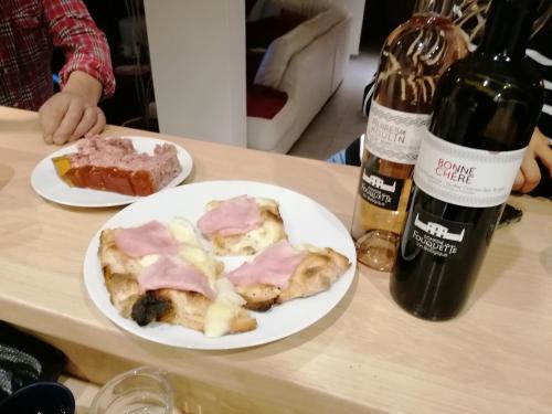 圣瓦利耶-德蒂耶Étape 85的一张桌子,上面放着两盘食物和一瓶葡萄酒