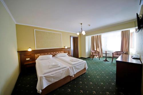 普雷代亚尔Montebello的酒店客房带一张床、一张桌子和椅子
