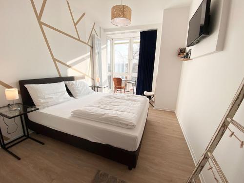 不莱梅Kangarooms - Schlachte Weserpromenade的一间卧室配有一张带电视和桌子的床。