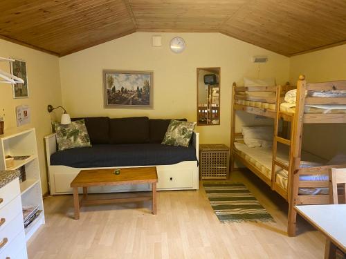 赫尔Ullstorps Stugor的带沙发和双层床的客厅