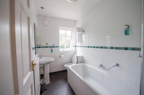 拉内利托马斯神臂酒店的白色的浴室设有浴缸和水槽。