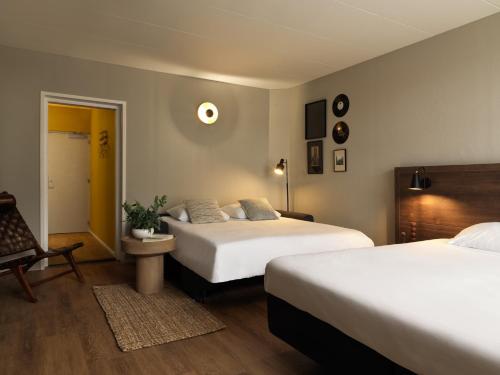 马斯特里赫特Townhouse Apartments Maastricht的酒店客房,配有两张床和椅子