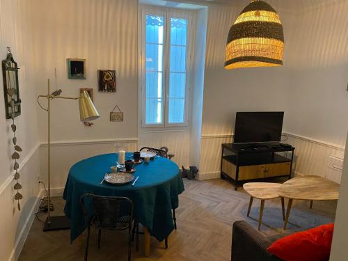 卢马罕Le cœur de Lourmarin Loulou en Luberon的客厅配有蓝色桌子和电视