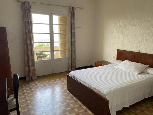 丹吉尔Hotel Le Gardenia (ex Lutetia)的一间卧室设有一张床和一个大窗户
