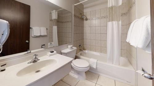 基洛纳休憩套房酒店的浴室配有盥洗盆、卫生间和浴缸。