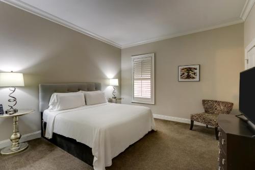 哈茨维尔The Mantissa Hotel的卧室配有白色的床和椅子