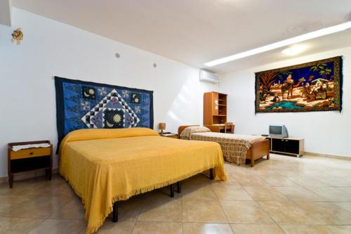 埃里切圣库苏马诺开放式空间公寓的一间卧室设有两张床,墙上挂着一幅画