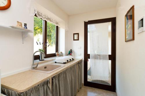 埃里切圣库苏马诺开放式空间公寓的厨房设有水槽和窗户。