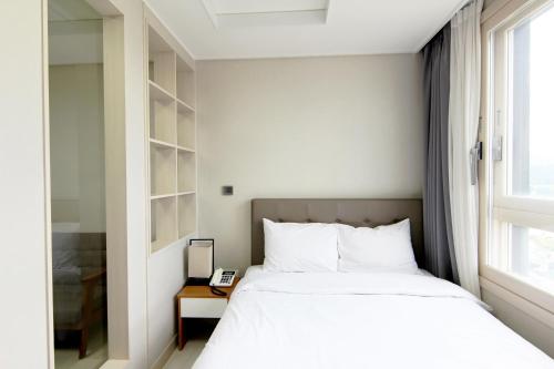 平昌艾姆酒店的一间卧室设有一张床和一个窗口
