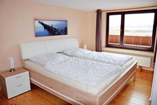 格罗斯齐克Ferienhaus mit Reetdach und Seebli的卧室内的一张床铺,设有大窗户