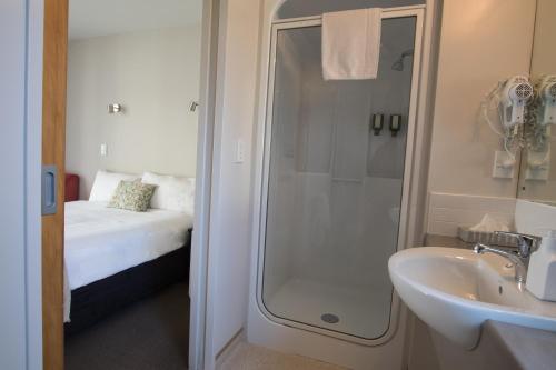 凯库拉凯库拉贝拉维斯特酒店的带淋浴和盥洗盆的浴室以及1张床。