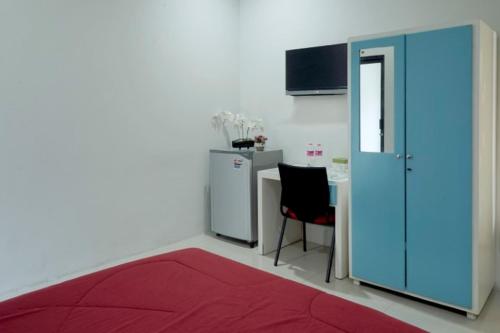 Alastuwo迪普瑞格凯杰优特旅馆的一间红色地毯、桌子和蓝色门的房间