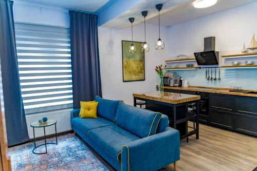 曼加利亚维拉卡萨菲娜服务式公寓的一间带蓝色沙发的客厅和一间厨房