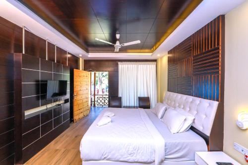 布莱尔港Pearl Park Beach Resort Private Limited的卧室配有白色的床和电视。