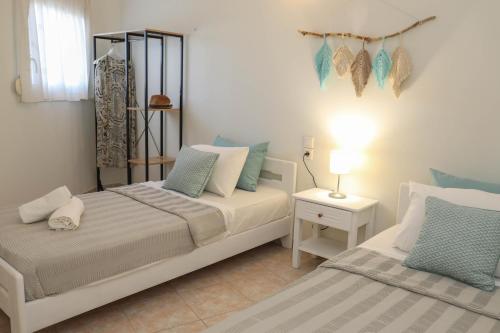 斯基亚索斯镇Tramontana House1的一间卧室配有两张带蓝白色枕头的床
