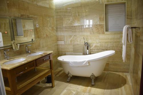 杜阿拉Hotel Royal Palace的一间带大浴缸和两个盥洗盆的浴室