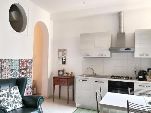 博洛尼亚Casa 28的厨房配有白色橱柜、桌子和用餐室。