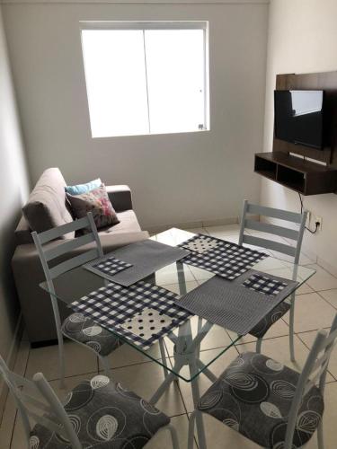 拉夫拉斯Aconchegante apartamento II的客厅配有玻璃桌和椅子