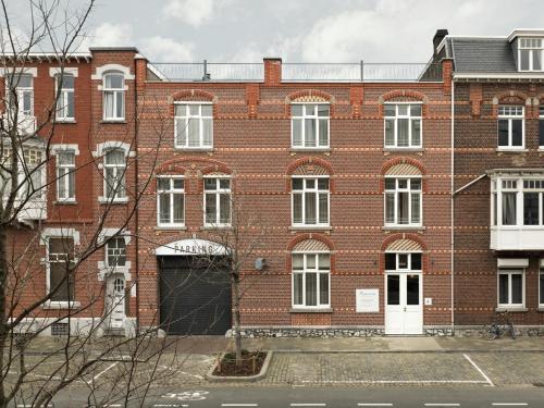 马斯特里赫特Townhouse Apartments Maastricht的一座大型红砖建筑,设有白色门