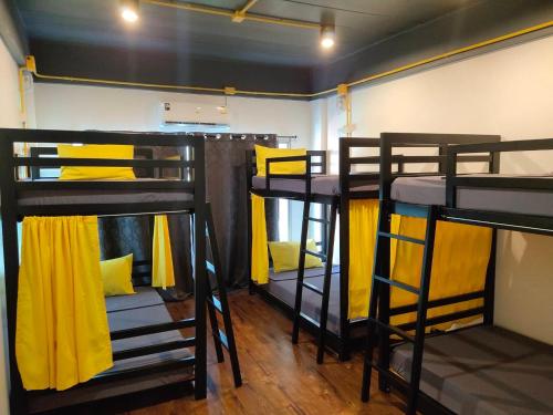 莱卡邦Best Bed Suvarnabhumi Hostel的客房设有3张双层床和黄色窗帘