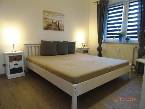 Groß KirrBirkenstr_14 a Wohnung 9的一间卧室配有一张带2个床头柜的大床