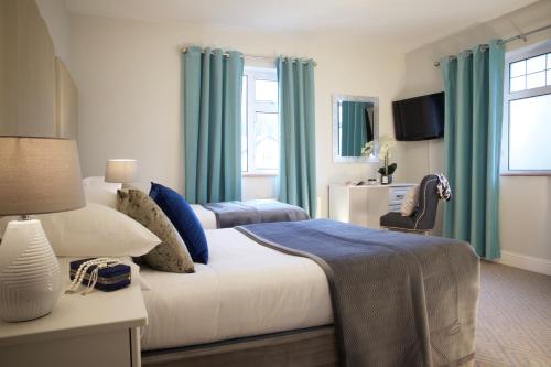 韦斯特波特Westport Heights的一间卧室配有一张带蓝色窗帘的大床