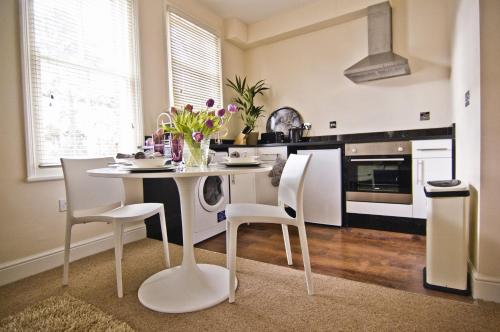 牛津诺亚住宅酒店的一间厨房,里面配有白色的桌子和椅子