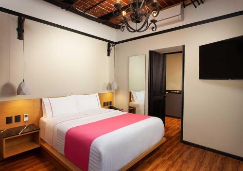 墨西哥城Hotel MX centro的一间卧室配有一张大床和一台平面电视