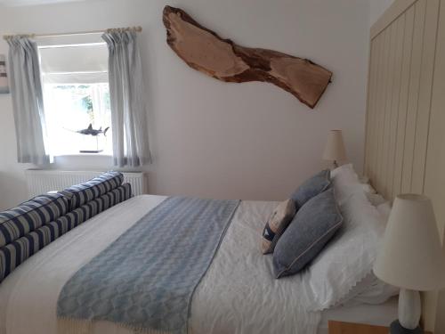 BishamptonThe Cobblers Bed and Breakfast的卧室配有带枕头的床铺和窗户。