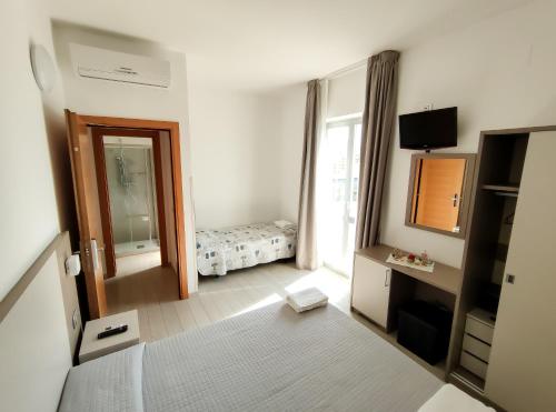 托尔托雷托Hotel Capitano的客房设有带一张床和镜子的卧室
