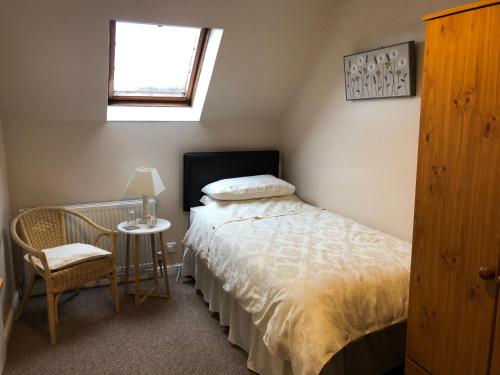 艾尔德里Fairview Bed and Breakfast的一间卧室配有一张床、一张桌子和一个窗户。
