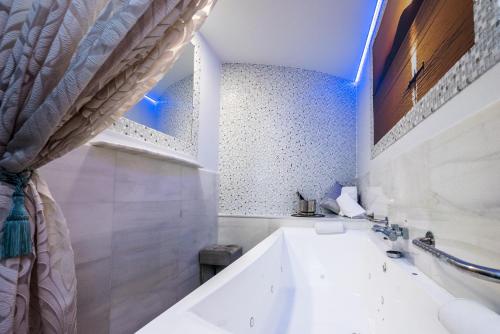 托雷洪-德阿尔多斯Hostal La Carretera的白色的浴室设有浴缸和水槽。