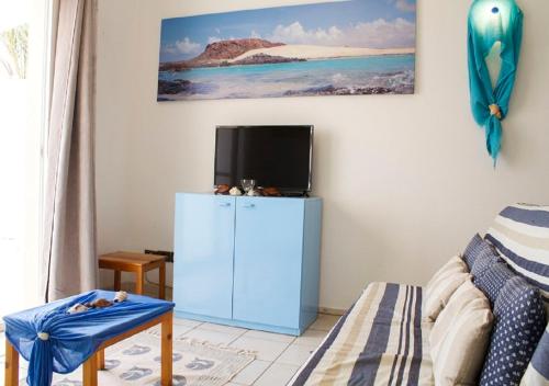 CabeçadasSea view houses, Praia de Chaves, Boa Vista, Cape Verde, FREE WI-FI的客厅配有蓝色橱柜和电视