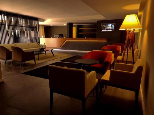格拉玛多Hotel Querência的客厅配有椅子、沙发和桌子