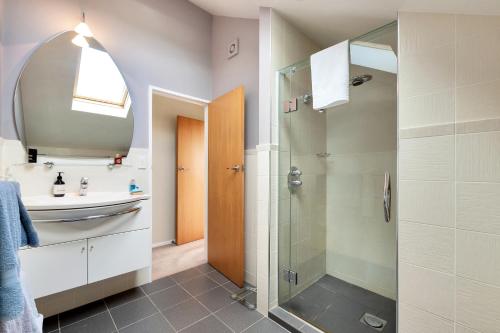 奥克兰Dangela Boutique Lodge的一间带玻璃淋浴和水槽的浴室