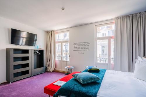 布鲁塞尔Smartflats - Pacific Brussels的一间卧室配有一张床和一台平面电视